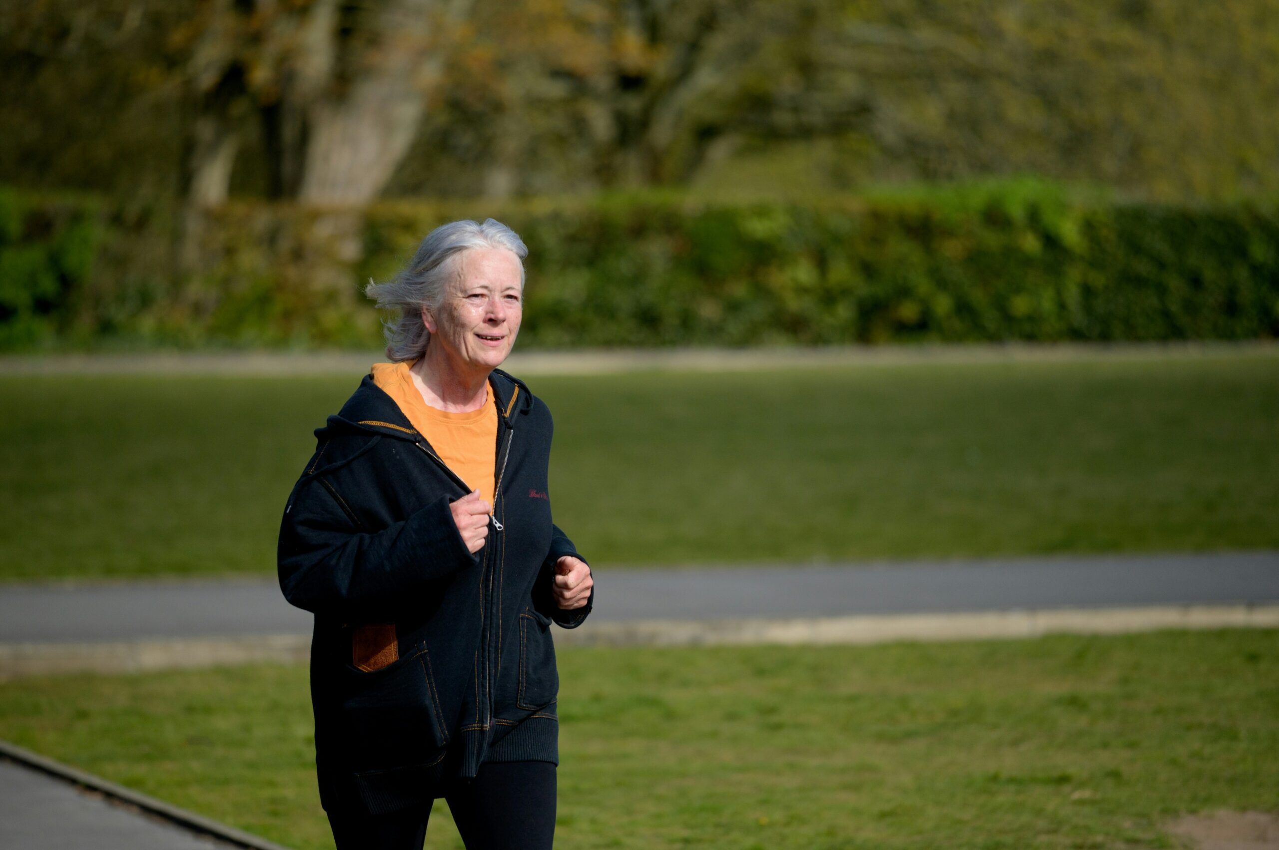Mulher idosa caminhando ao ar livre em um parque