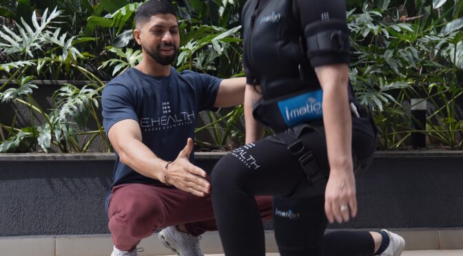 Personal trainer faz sinal de positivo ao lado de cliente em treino ao ar livre
