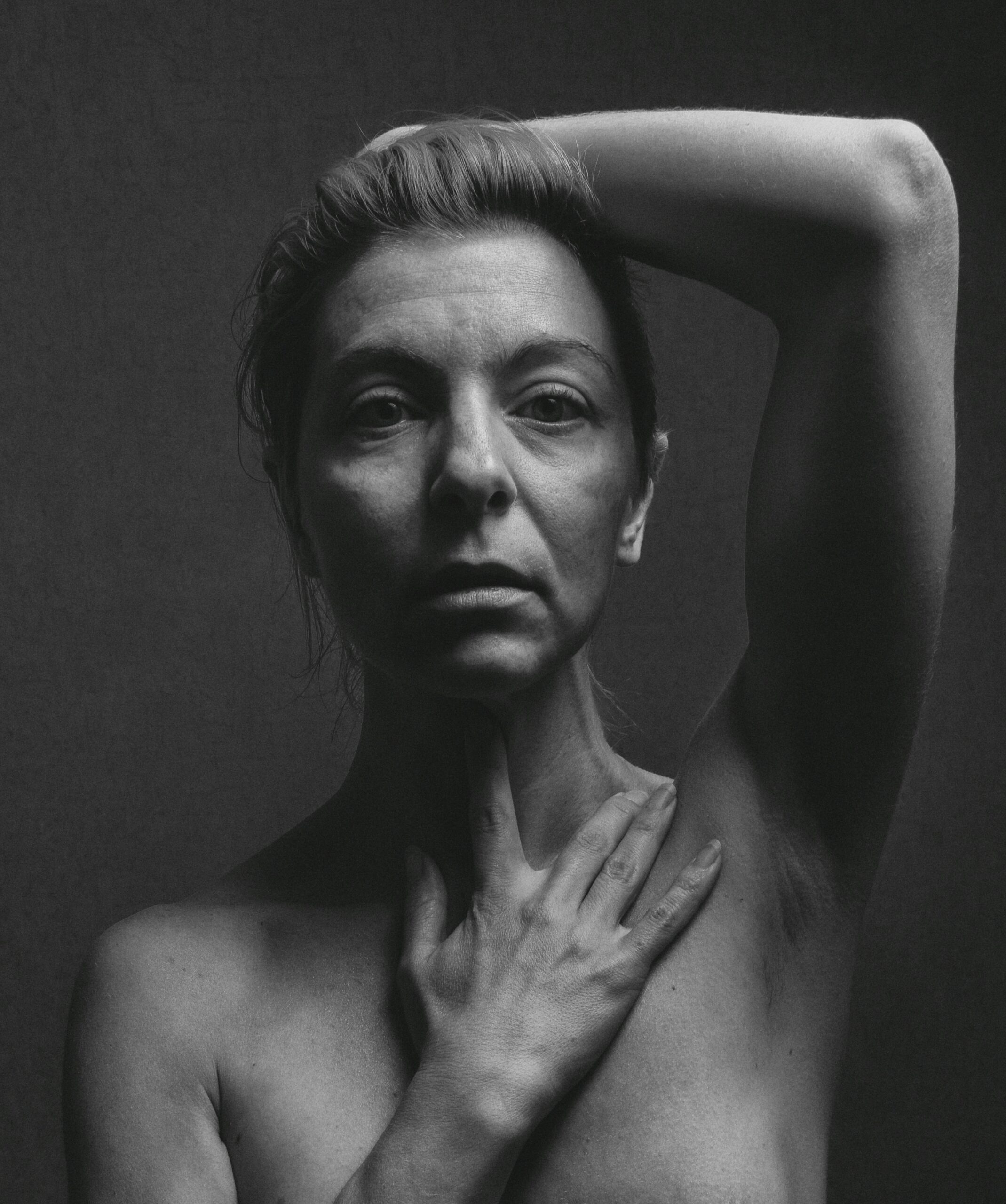 Retrato em preto e branco de mulher madura com a mão no peito