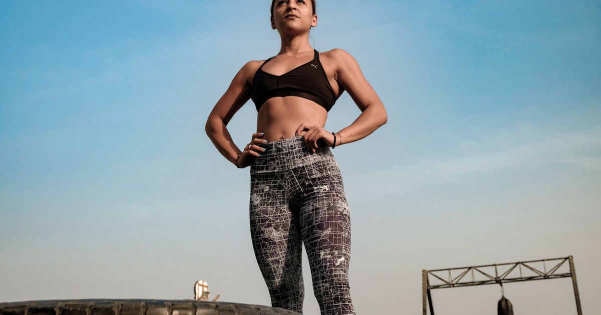 Mulher fisicamente em forma, representando treino de força e EMS