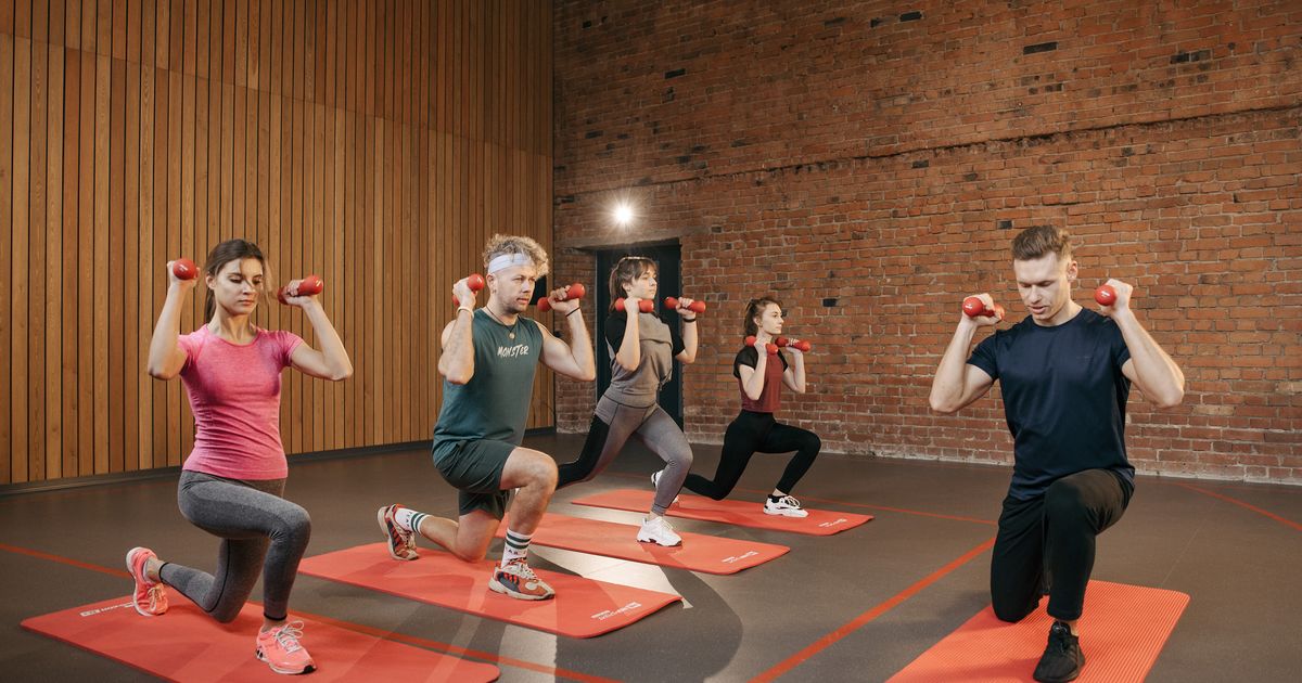 Pessoas se exercitando com halteres, representando estímulo muscular